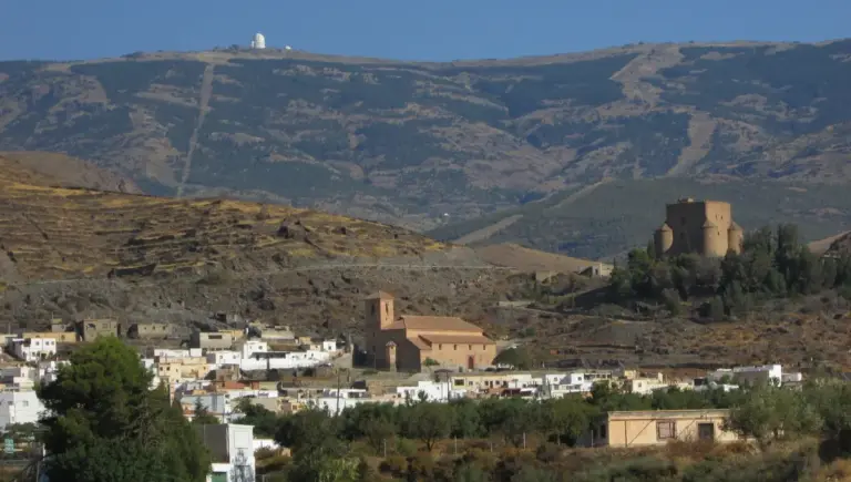 Il paese di Gérgal con il suo castello e la chiesa, e sullo sfondo la cupola dell'Osservatorio di Calar Alto sul crinale della Sierra de los Filabres