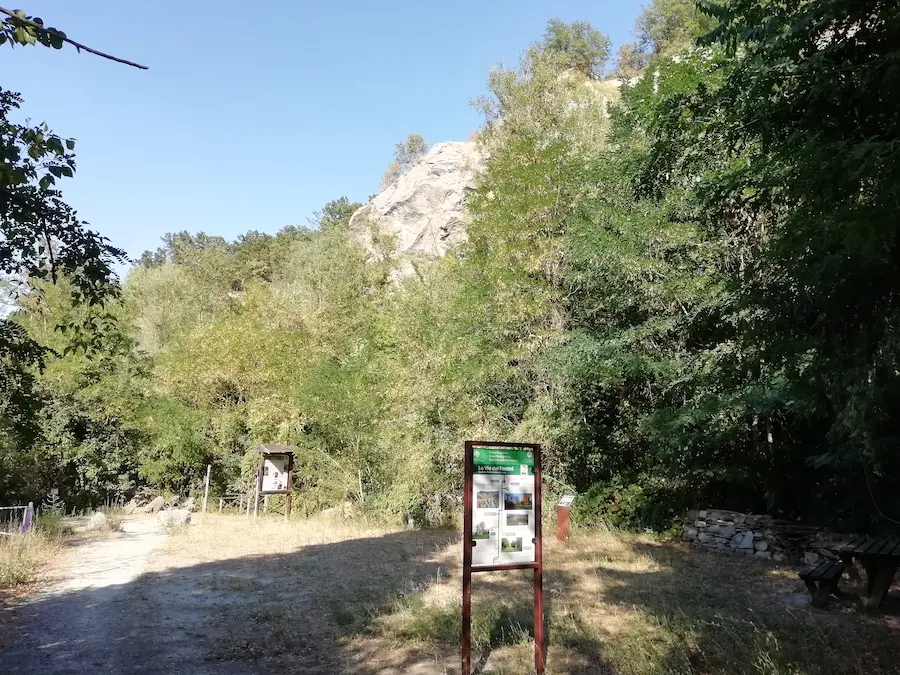 Sentiero della Via del Fantini verso il sottoroccia del Farneto, con pannello informativo del Parco dei Gessi Bolognesi e affioramento roccioso sullo sfondo