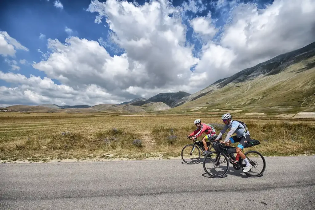 Ciclisti attraversano un paesaggio montano in Italia