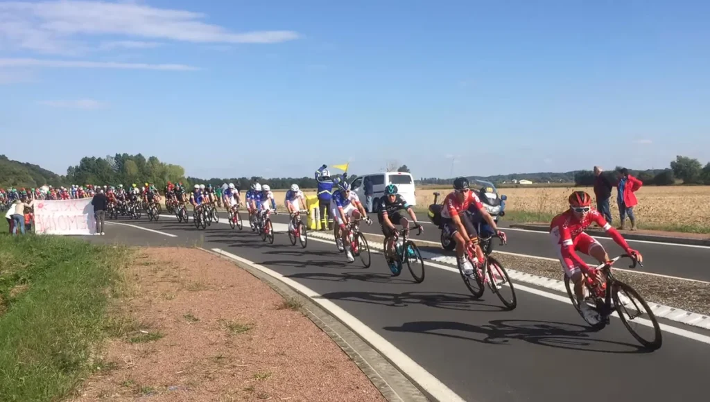 Il gruppo dei ciclisti durante la Paris–Tours 2016, impegnato lungo una strada di campagna francese, con alcuni corridori in primo piano.